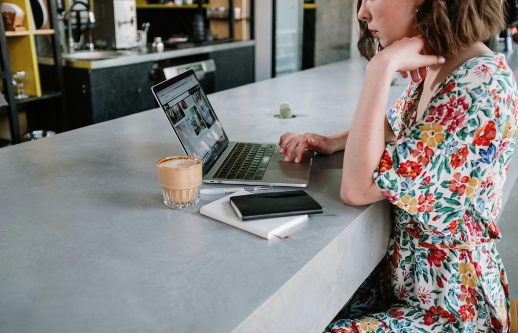 A young woman working on a laptop in a coffee shop.