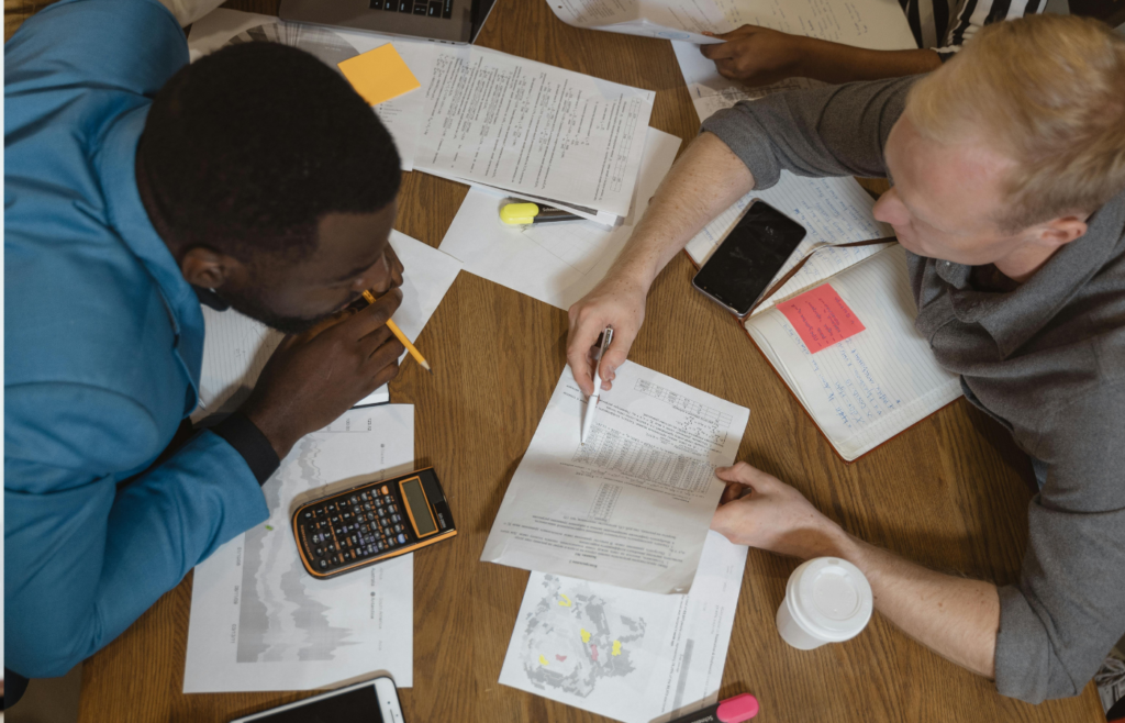 two person surrounded by financial books