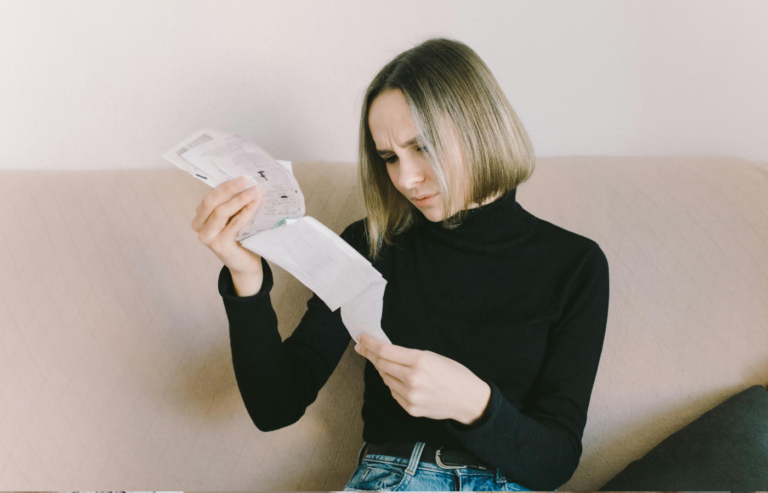 A worried woman looking at a single paycheck