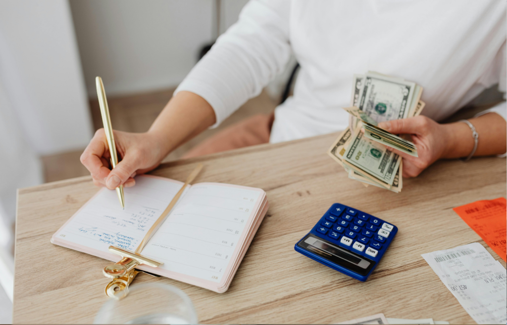 A person writing out a budget in a notebook