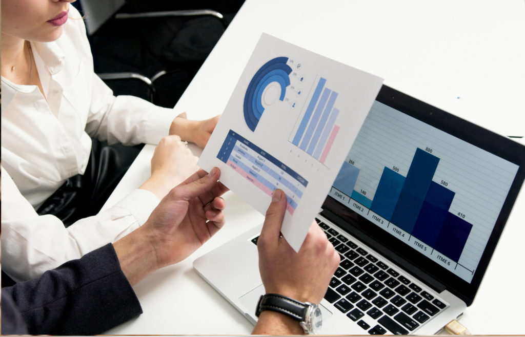 A business professional analyzing a graph on a laptop