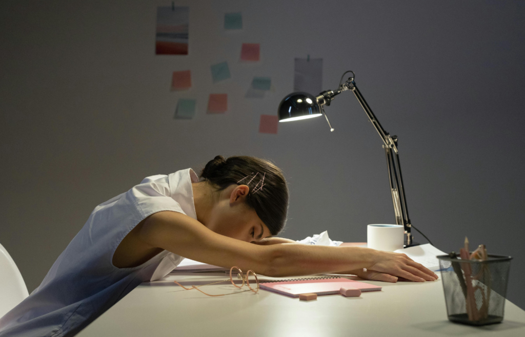 A tired worker at a desk late at night.