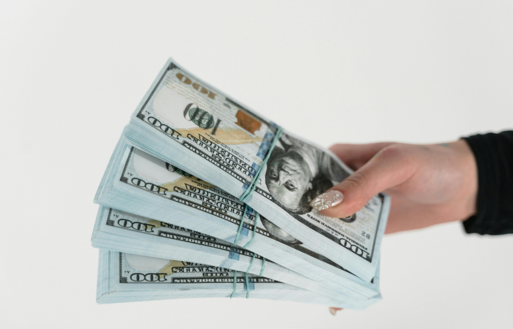 A hand holding a stack of money.