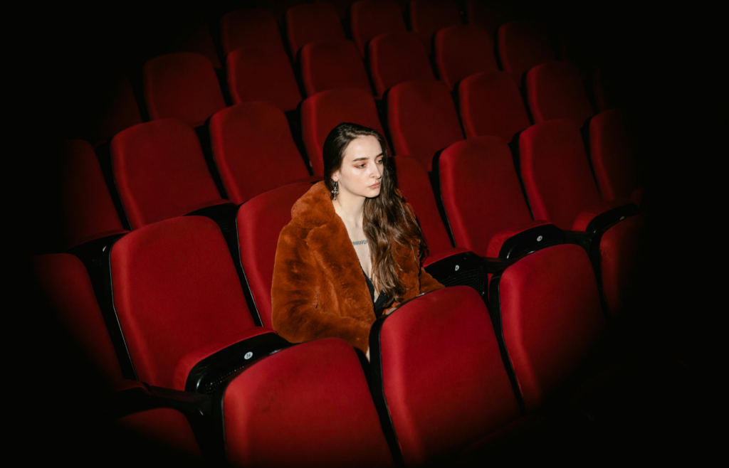 A woman sitting alone in a empty studio.