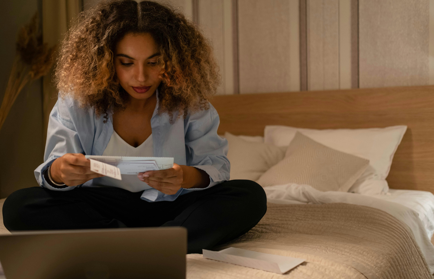 A woman looking confused while she attempting to budget on a laptop