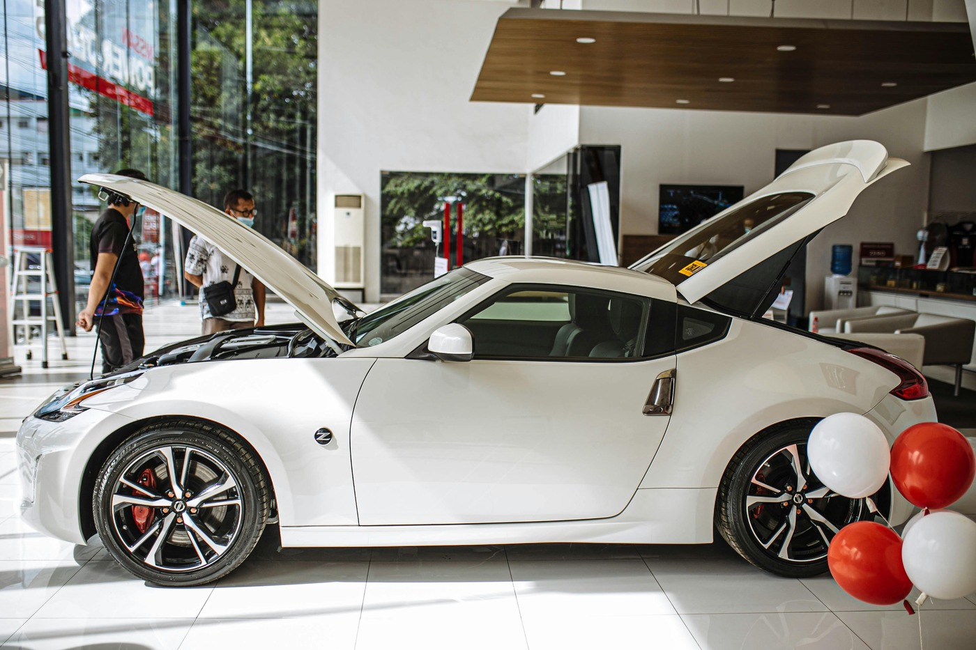 person looking proudly at their shiny new car in a dealership