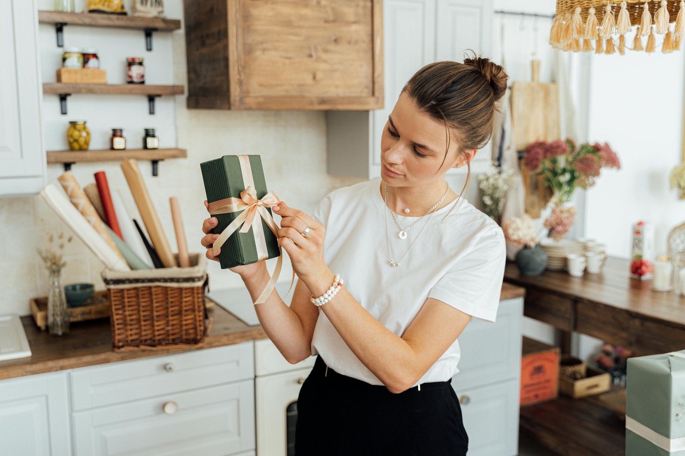 Woman in White Shirt Holding fancy wrapped gift