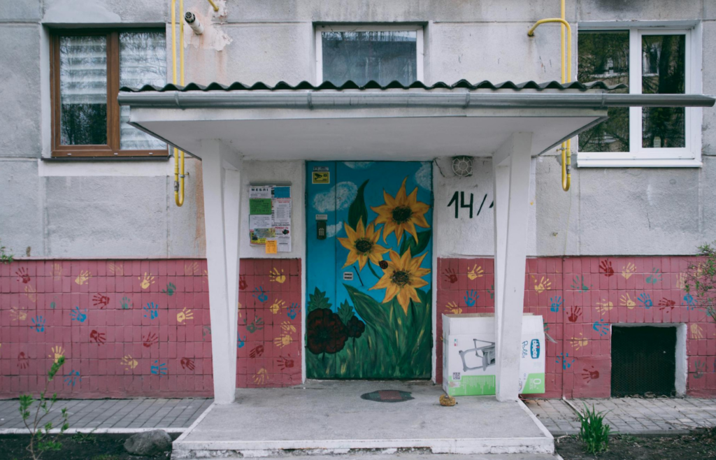 A well-maintained front yard with vibrant plants and a freshly painted front door
