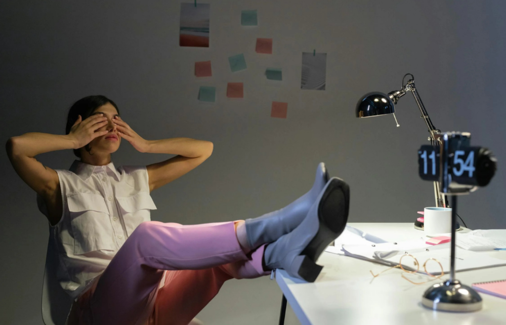 The girl is sleeping with her feet on the table