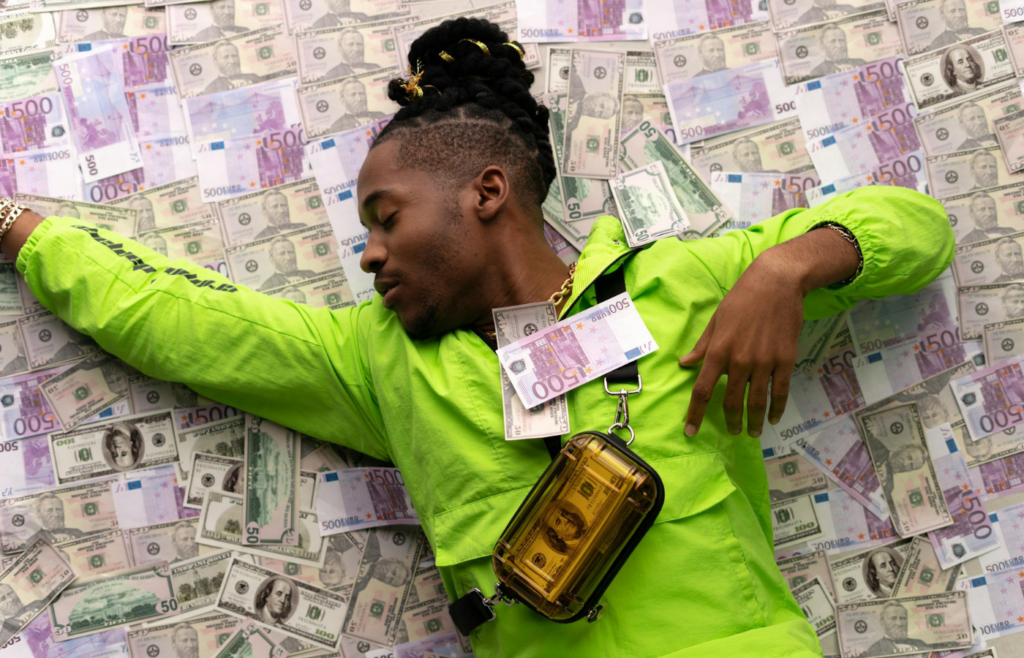 Man in Green Jacket Lying Down on Money