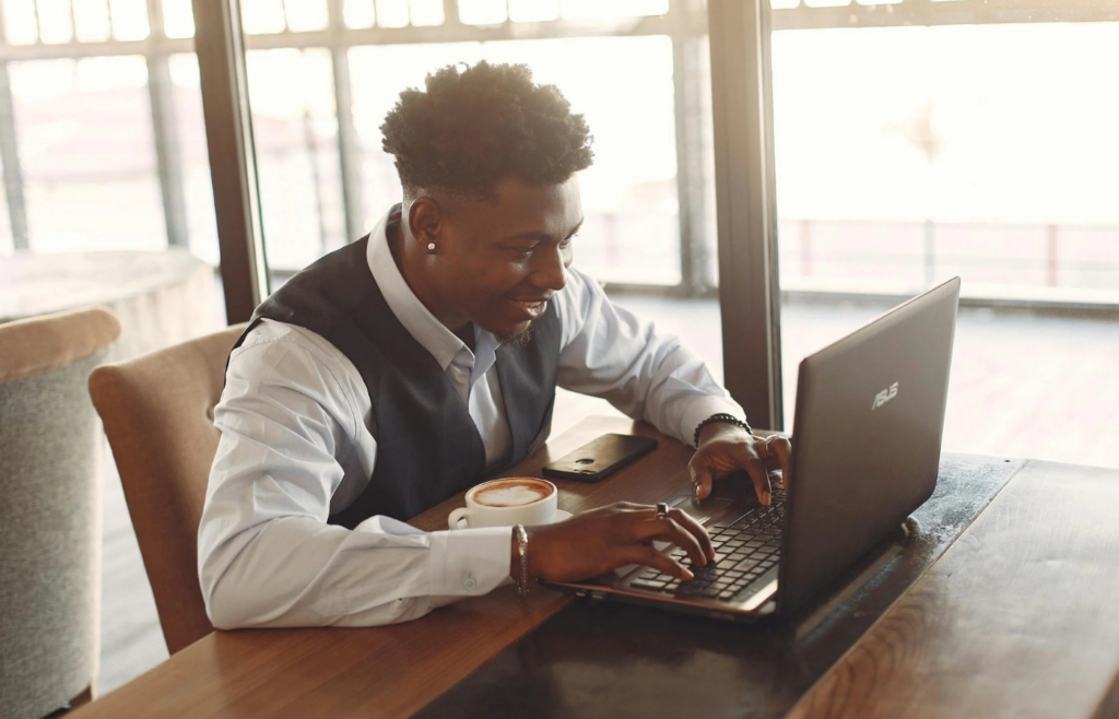 A person sitting with a laptop and coffee