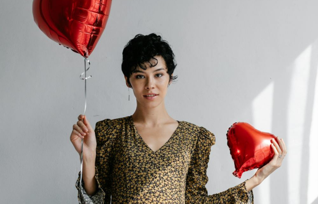 Woman holding Two Red Heart-shaped Balloons