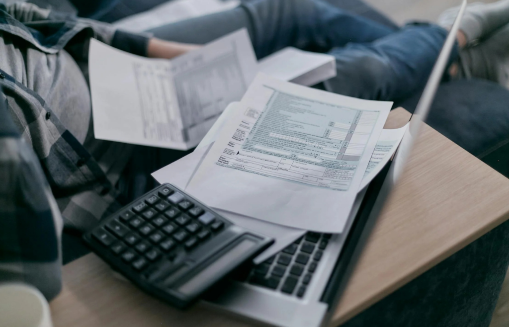 An individual reviewing a monthly budget on a laptop