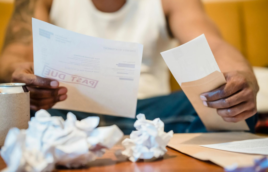 An individual reviewing a dwindling bank account statement