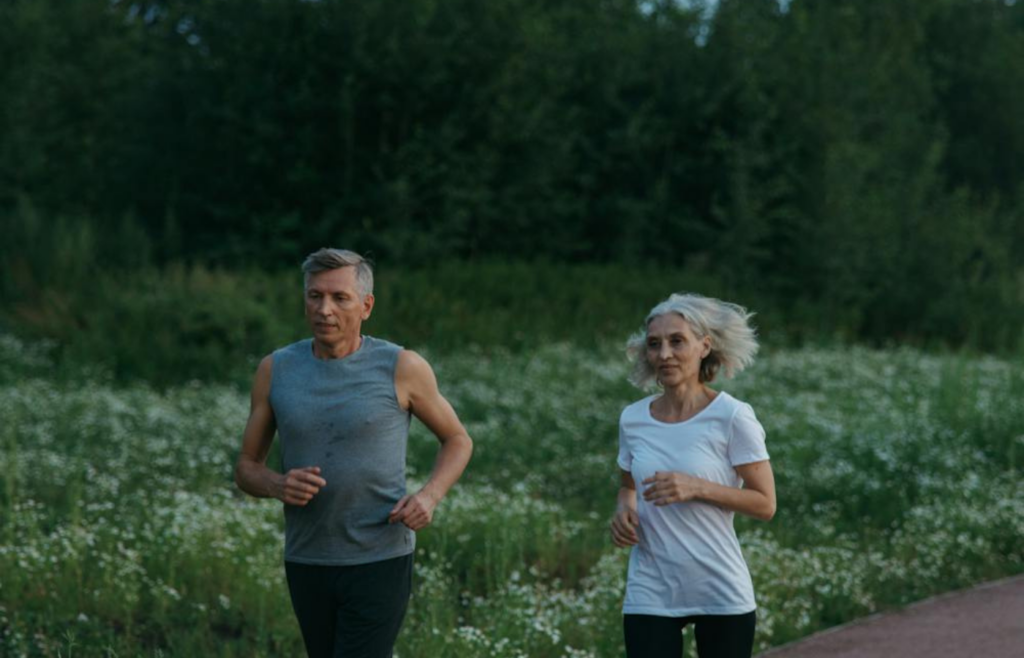 An elderly couple jogging in a park