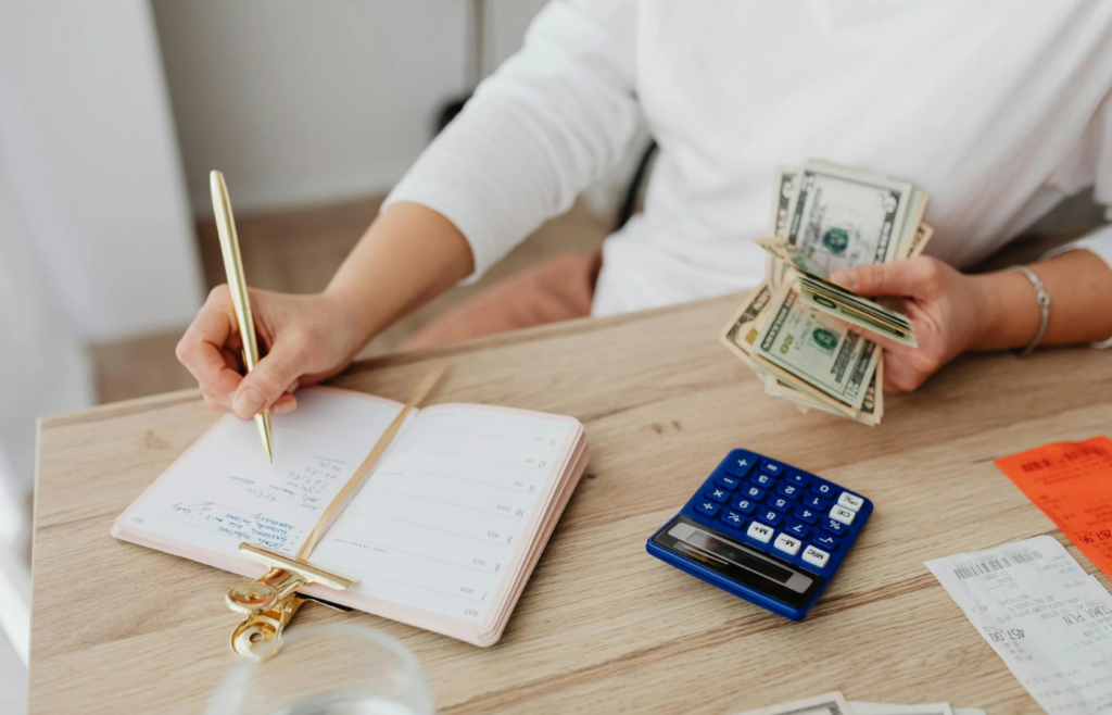 A person writing financial goals in a notebook