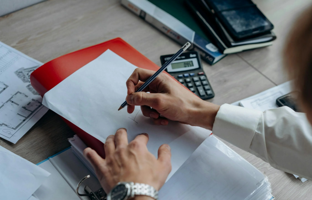 A pension check alongside a calculator and retirement plan documents