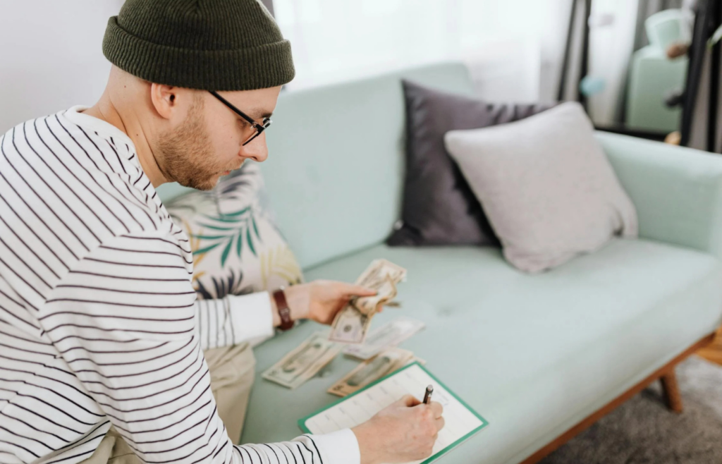 Man writing on a paper while sitting on green couch
