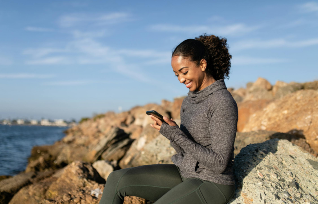A person smiling while looking at their smartphone
