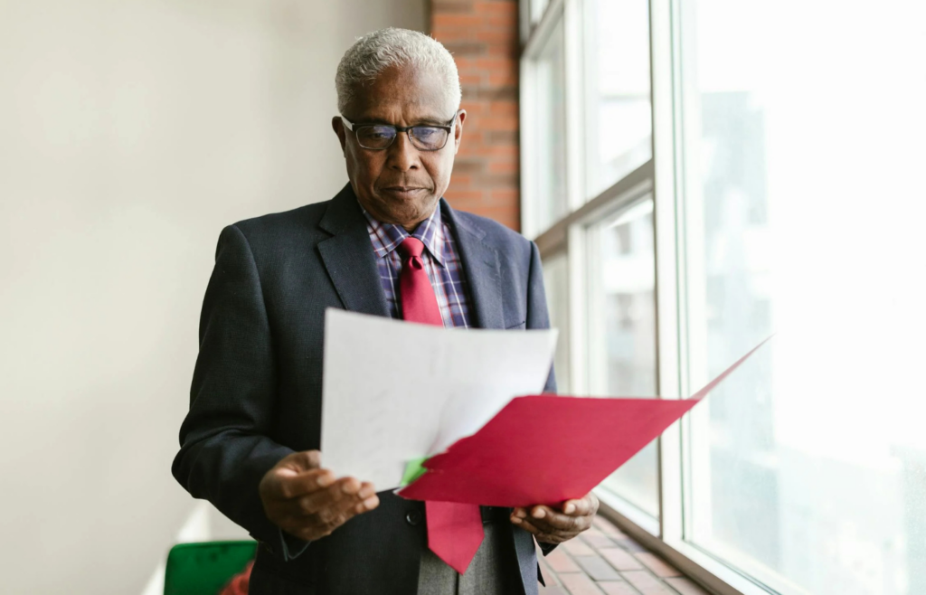 An elderly person reviewing a bank statement with a concerned expression