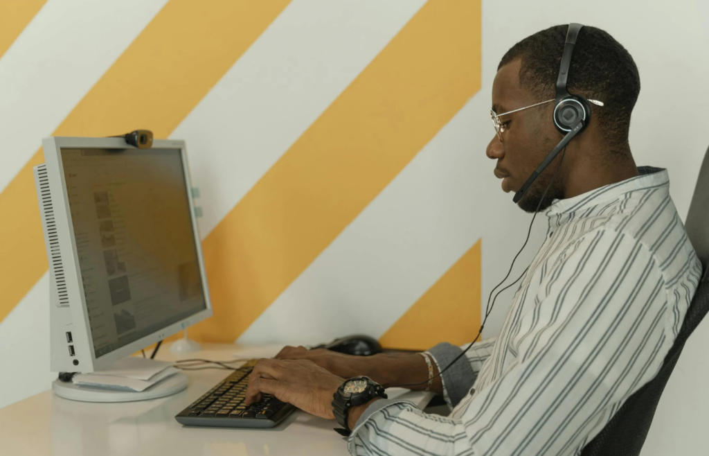 An employee working on a computer with a surveillance camera in the background