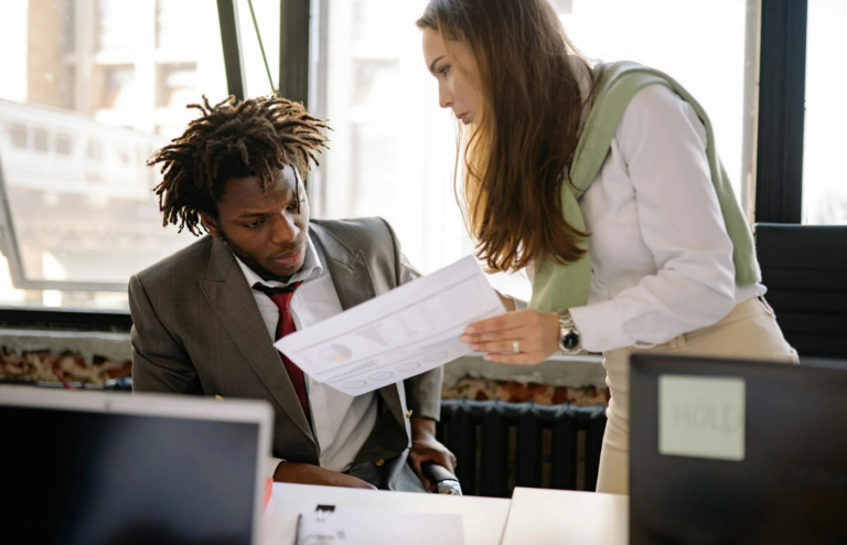 An employee receiving a document labeled Performance Improvement Plan' from a manager