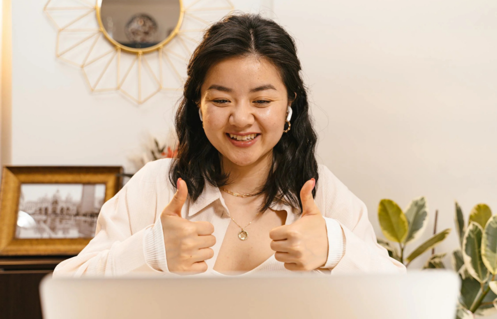 A woman in a video call doing a Thumbs Up