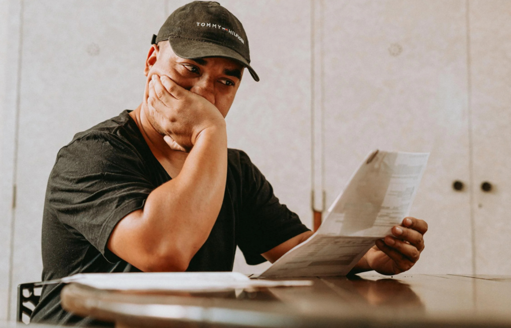 A man observes bills with a concerned expression