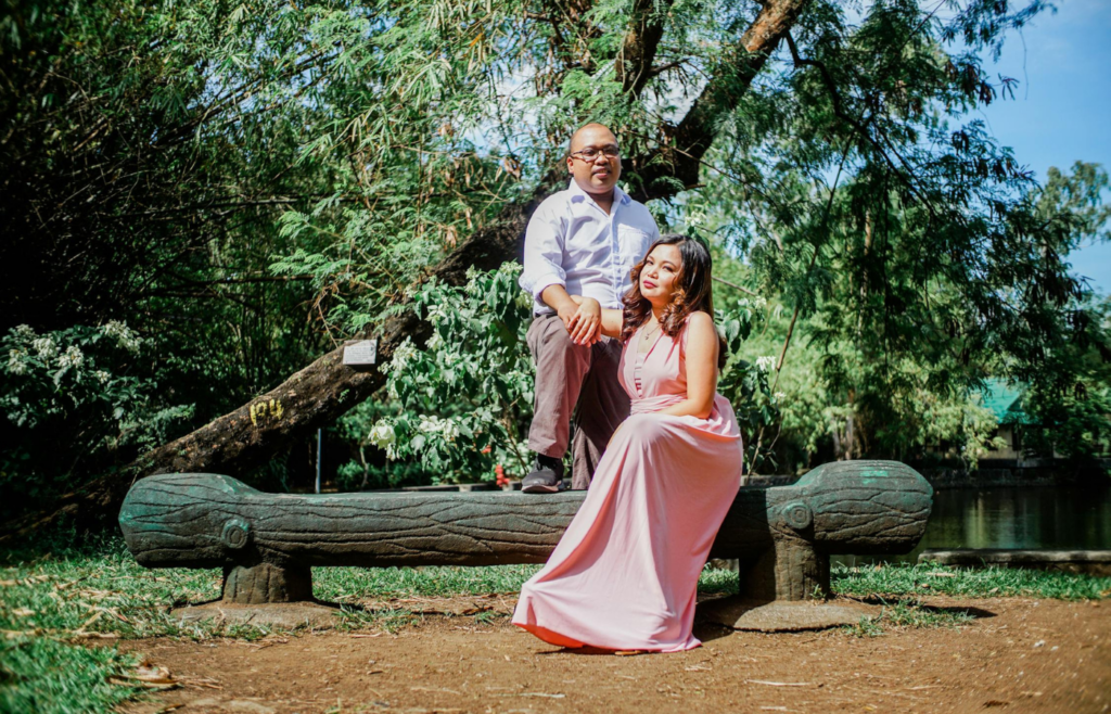 A couple sitting apart on a park bench, looking away from each other