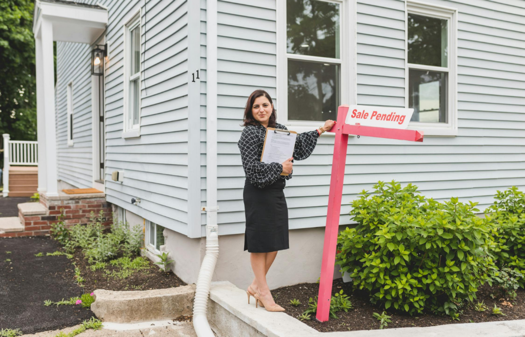 A person negotiating a property purchase with a 'Sale Pending' sign in the background