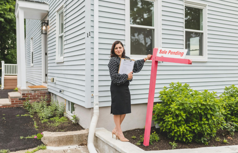 A person negotiating a property purchase with a 'Sale Pending' sign in the background