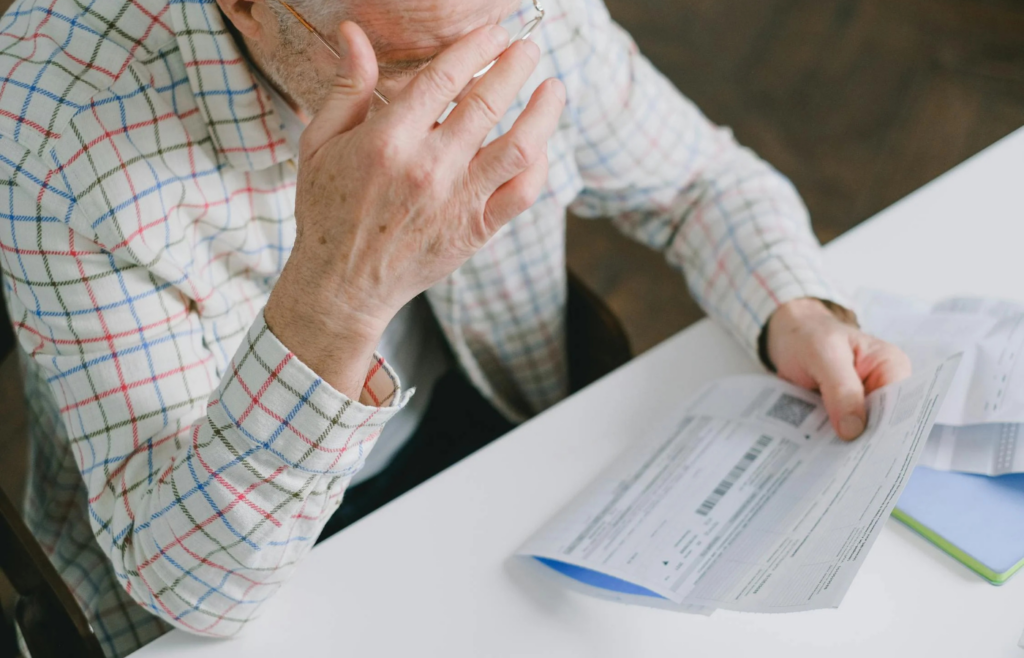 A person overwhelmed with financial documents at a desk