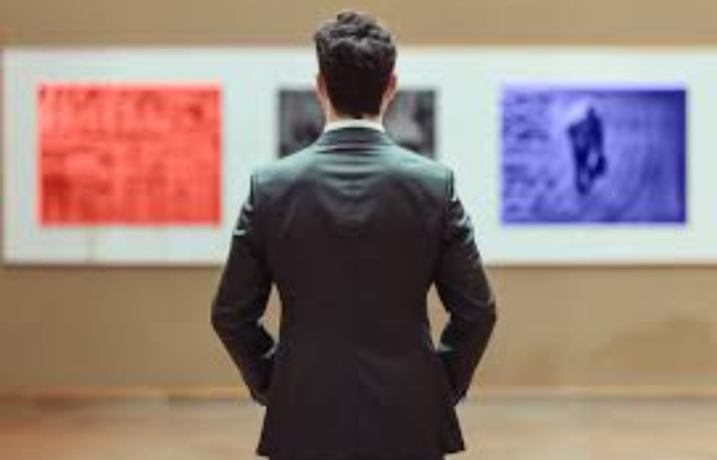 Man viewing colourful framed artworks