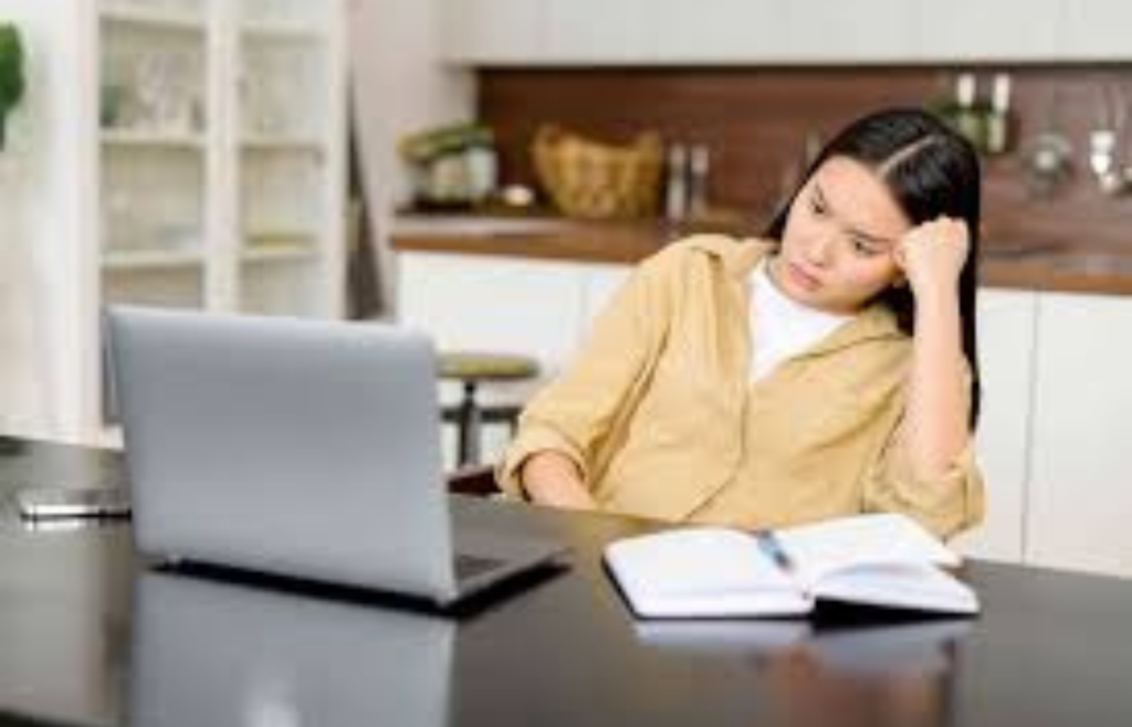 A person at a desk, deep in thought with a conflicted expression
