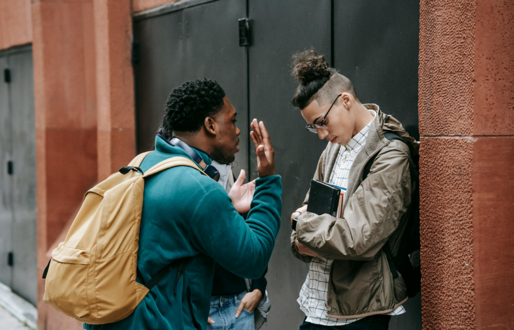 Two people talking near a building
