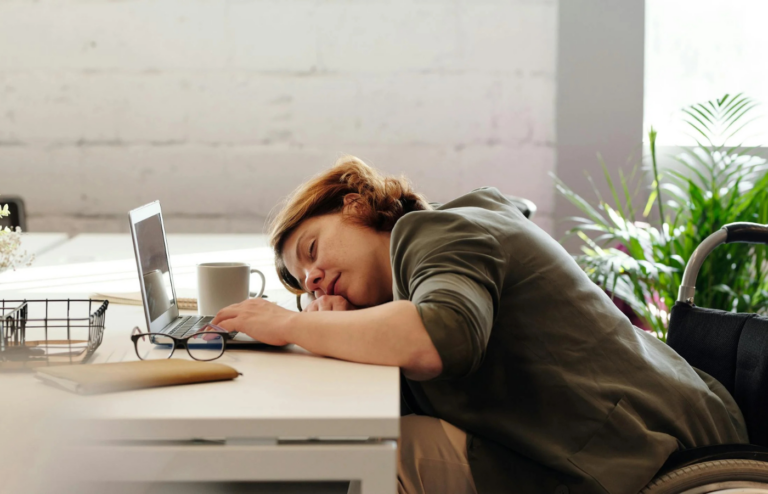 A tired employee working late with empty coffee cups around