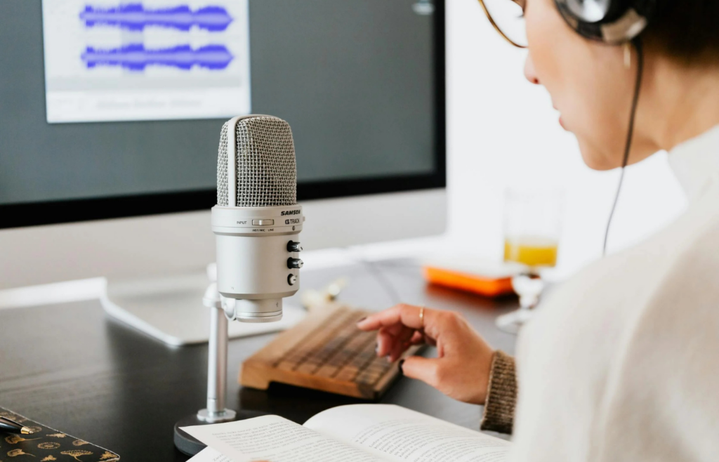 A person editing a script next to a podcast mic