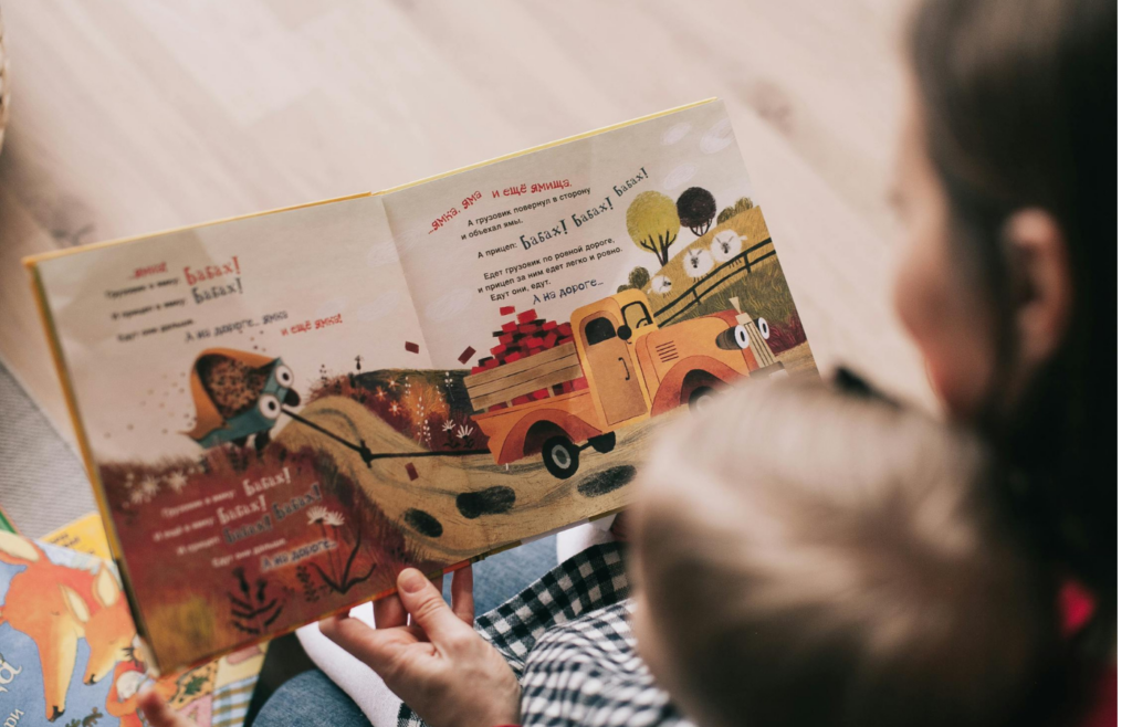 A parent reading a custom-illustrated book with a child