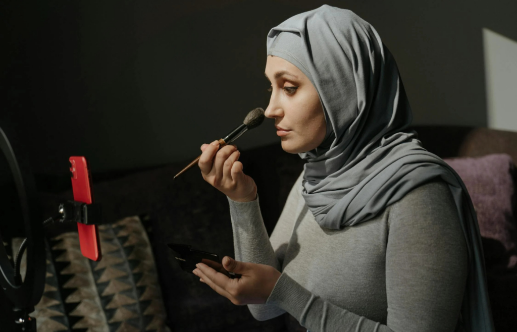 A person filming a makeup tutorial on their phone