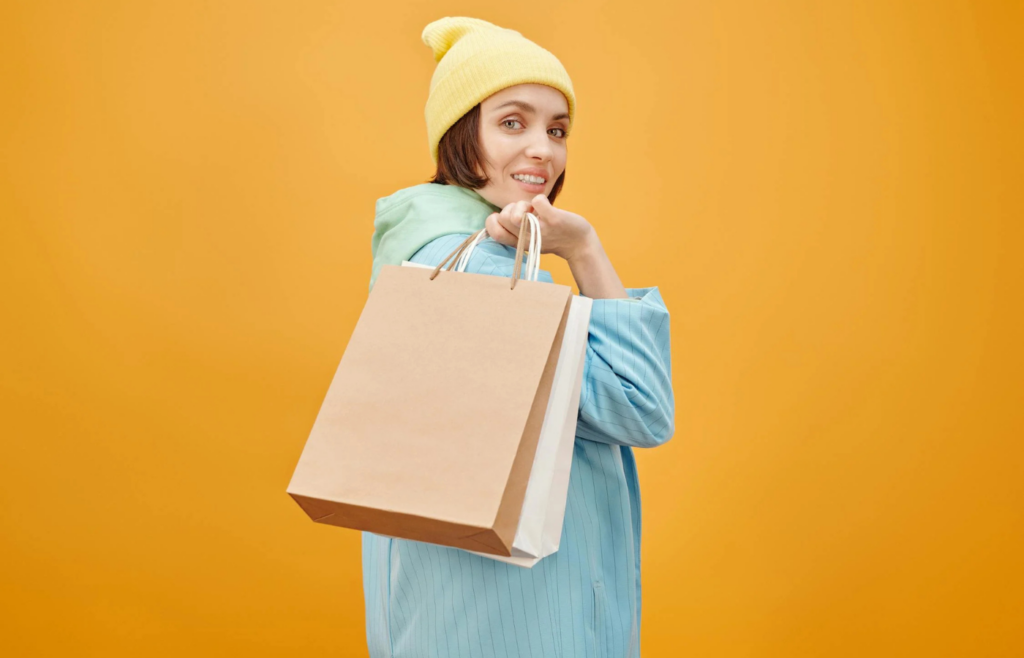 A person juggling multiple shopping bags with a concerned expression