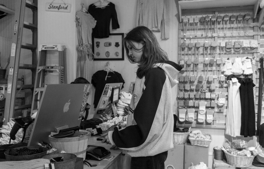 A shopper reaching for items near a store's checkout counter
