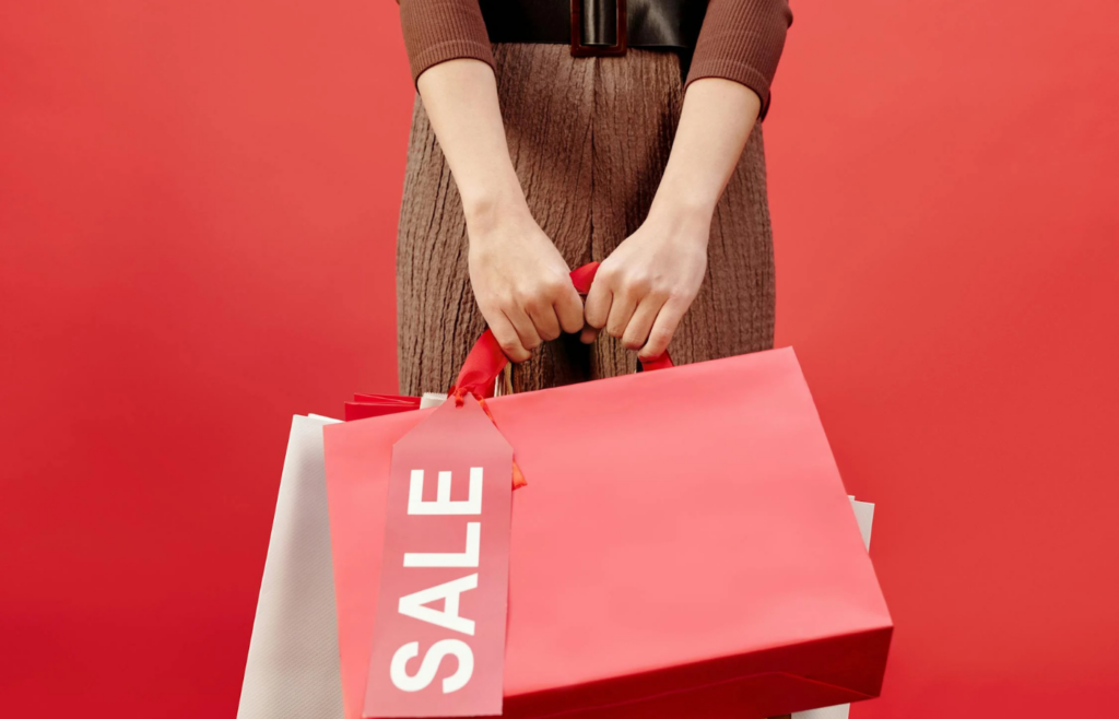 A shopper loading a cart with items from a 'buy one, get one' sale