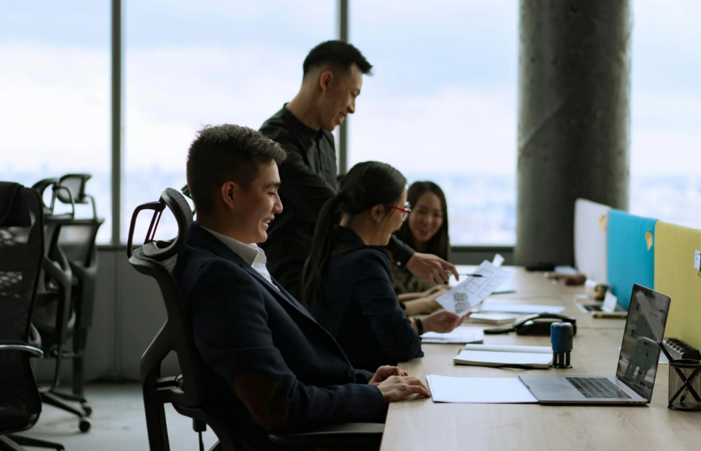 A group of employees having a meeting while intentionally leaving one colleague out