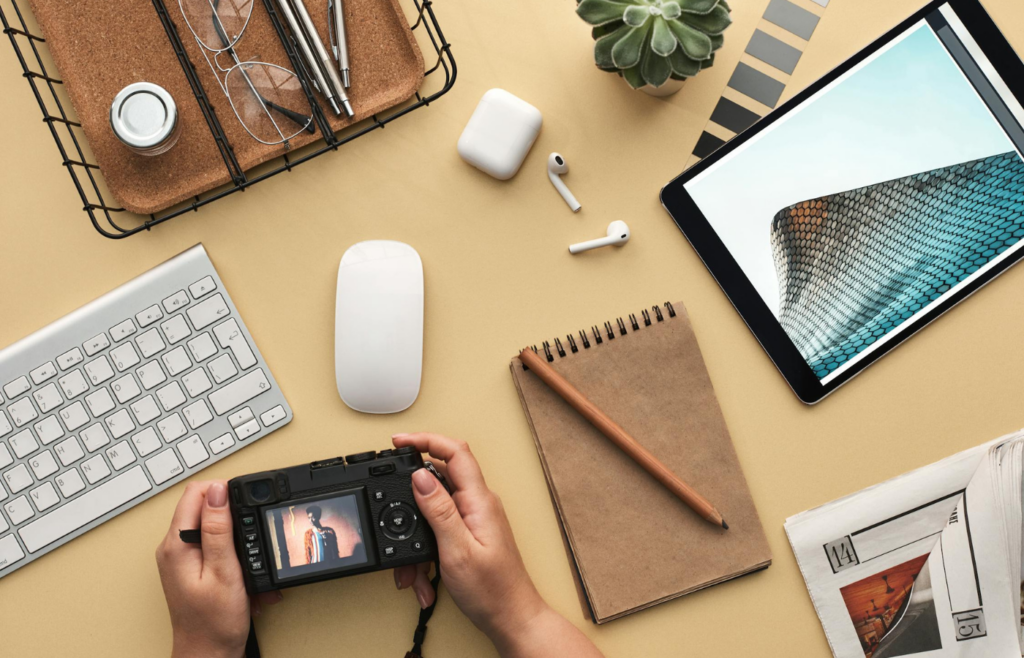 A cluttered desk filled with various planners, apps, and gadgets