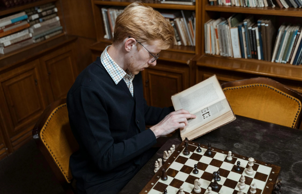  A person surrounded by books and devices, looking confused