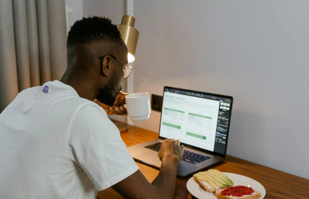 A person eating at their desk while typing