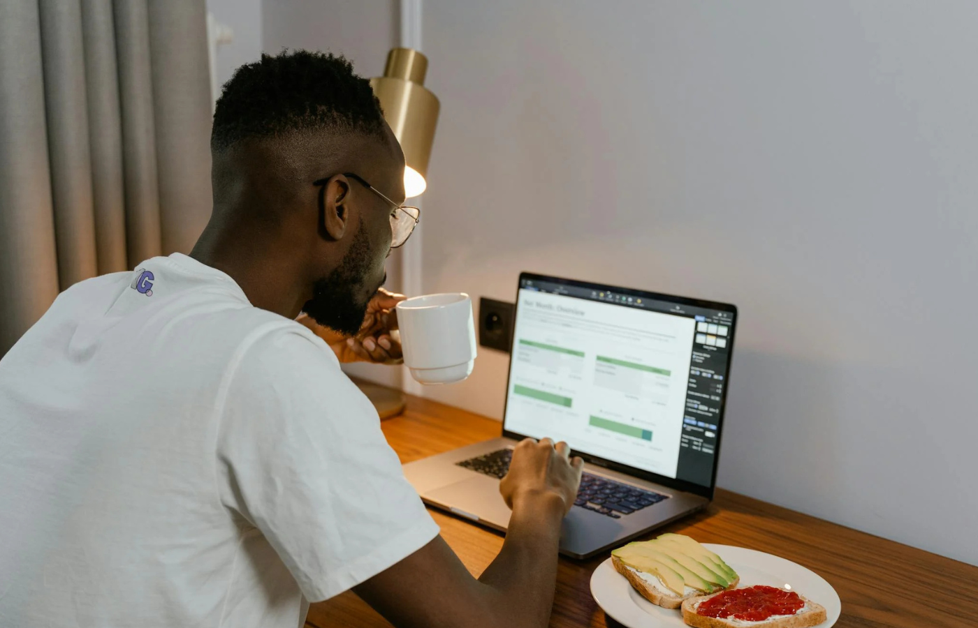 A person eating at their desk while typing