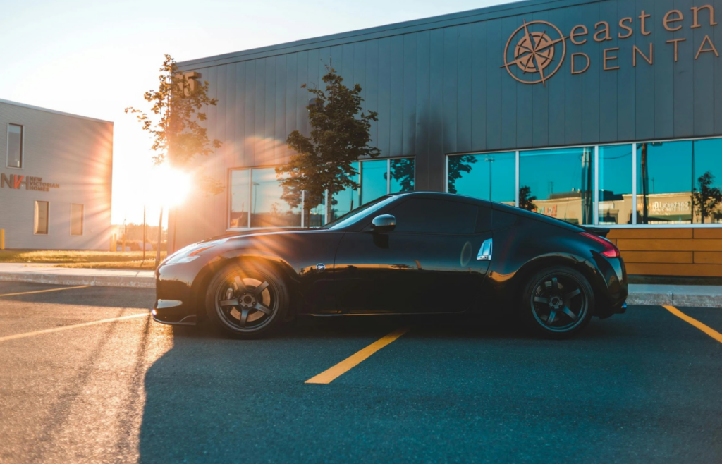 A parked car in a driveway at sunrise