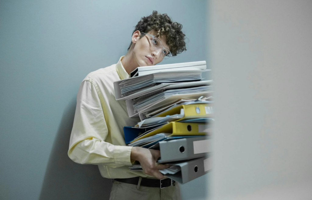 An employee buried under a pile of paperwork