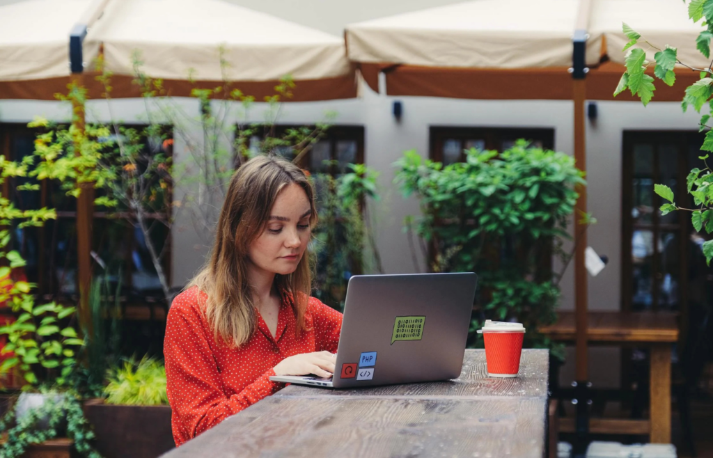 A freelancer working on a rooftop patio with a laptop